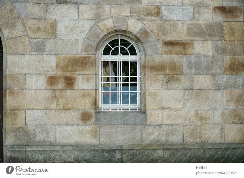 Mauer mit Blöcken aus Kalksandstein, perfekt gemauert mit Rundbogen und vergitterten Fenster Wand Fassade Gebäude Architektur Bauwerk mauerwerk Mauerstein