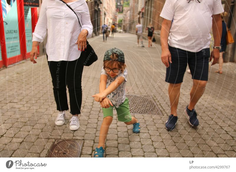 Kind mit Brille, das unter der Aufsicht von zwei Erwachsenen spielt Mensch Gefühle Eltern Familie & Verwandtschaft Fröhlichkeit Kindheit Spielen spielerisch