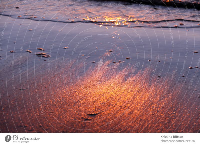 die untergehende sonne spiegelt sich auf dem nassen sand sonnenlicht spiegelung wasser meer strand dämmerung sonnenuntergang sonnenaufgang reflektion reflexion