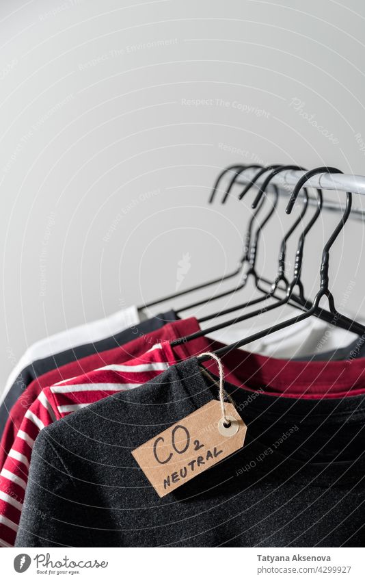 Kleidung mit Kohlenstoff-Emissionslabel Kleiderbügel Schiene kennzeichnen neutral Laden Einzelhandel Werkstatt Ablage Sekundenzeiger lässig Kauf Textil anhaben