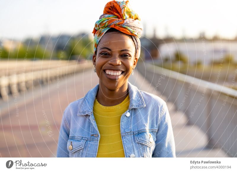 Porträt einer lächelnden jungen Frau in der Stadt Afro-Look stolz echte Menschen Stadtleben Afroamerikaner Afrikanisch Schüler schwarz Ethnizität sonnig