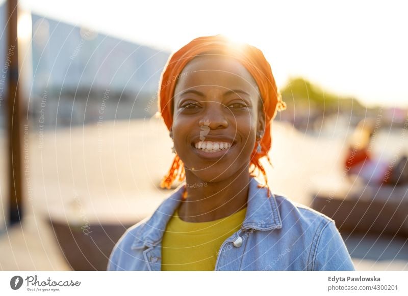 Porträt einer lächelnden jungen Frau in der Stadt Afro-Look stolz echte Menschen Stadtleben Afroamerikaner Afrikanisch Schüler schwarz Ethnizität sonnig