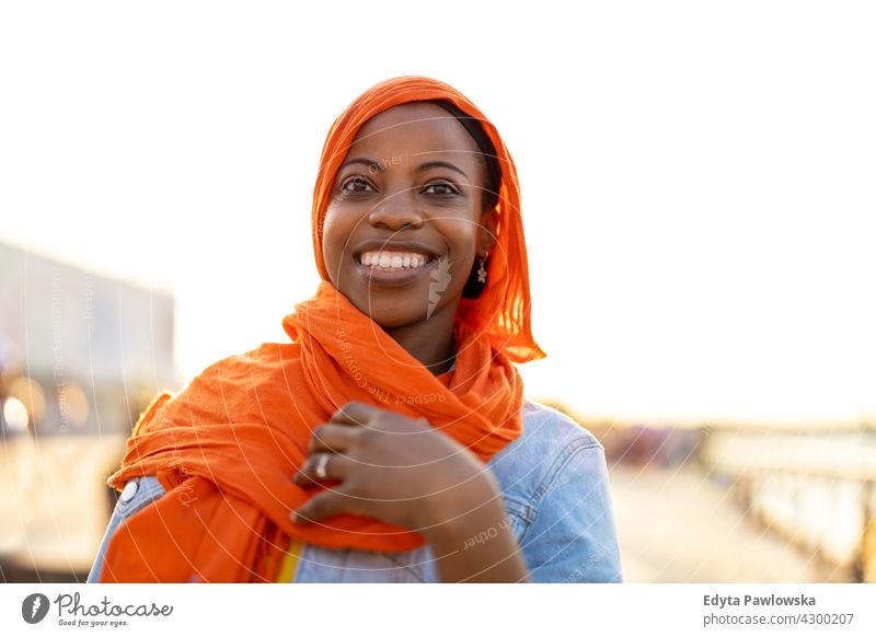 Junge Frau in Hijab im Freien bei Sonnenuntergang Afro-Look stolz echte Menschen Stadtleben Afroamerikaner Afrikanisch Schüler schwarz Ethnizität sonnig