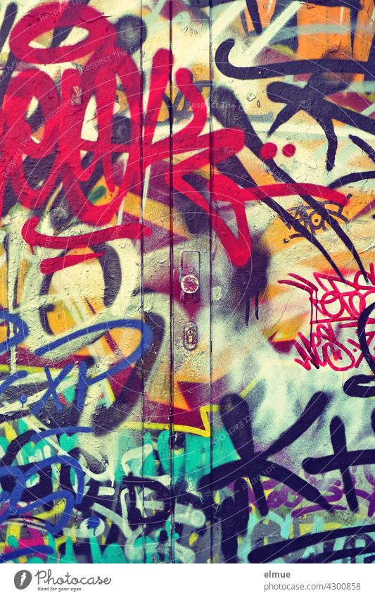 Graffiti an einer geschlossenen Metalltür / sprayen / Farbe bunt Sprayer unleserlich Schmiererei Sachbeschädigung Kunst Jugendkultur Vandalismus Subkultur Tür