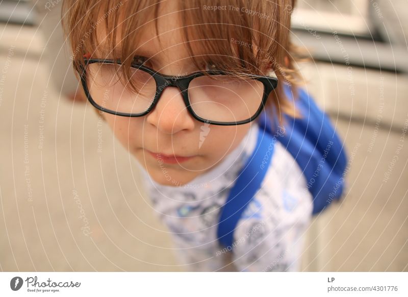 Kind mit Brille schaut neugierig in die Kamera Stil Design Mensch Gefühle Farbfoto Eltern Kontrast Hintergrund neutral Strukturen & Formen Erholung Sinnesorgane