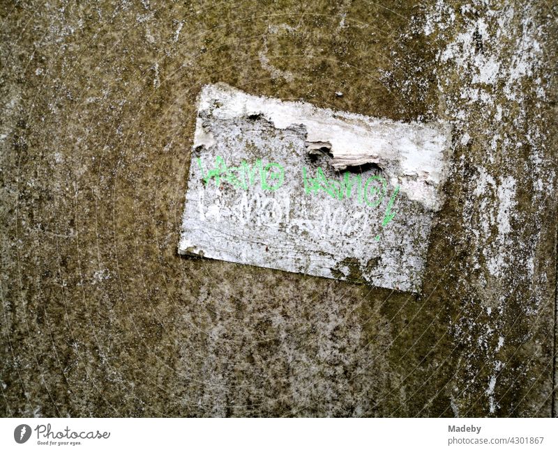 Vergilbter und aufgeweichter alter Papieraufkleber auf einem Verteilerkasten mit Patina in Oerlinghausen bei Bielefeld im Teutoburger Wald in Ostwestfalen-Lippe