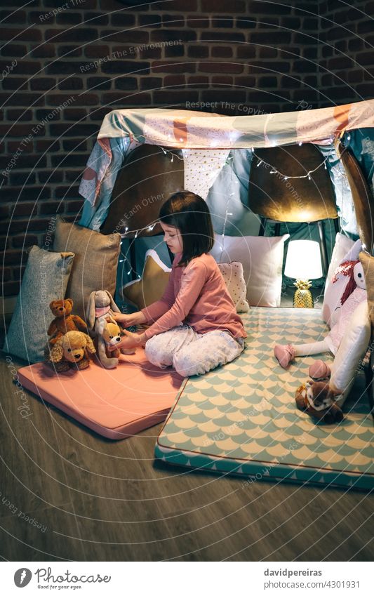Mädchen spielt mit ausgestopften Tieren in einem Tipi lieblich spielen Tierpräparat Spielmatten Bettwäsche Stühle Kind Kindheit Frau Spielzeug Freude Liebe süß