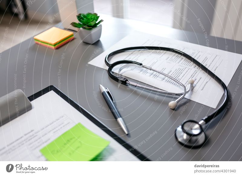 Schreibtisch des Arztes mit Stethoskop und Dokumenten medizinische Dokumente Arztschreibtisch Zwischenablage Schreibstift niemand Pflanzen Tisch Gerät