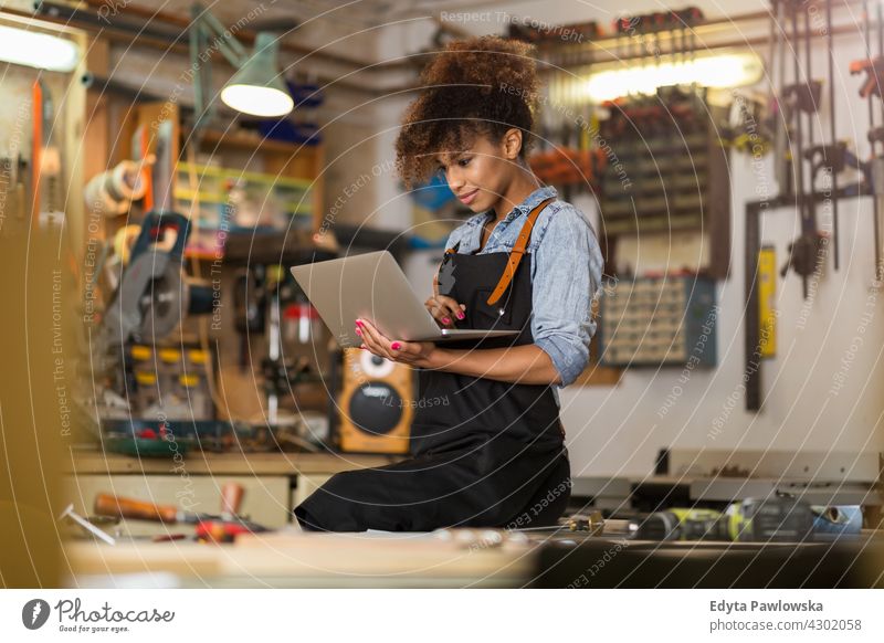 Selbstbewusste junge Frau bei der Arbeit in der Werkstatt Besitzer Beruf Dienst Kleinunternehmen Mitarbeiter arbeiten Techniker Arbeitsplatz Arbeiter