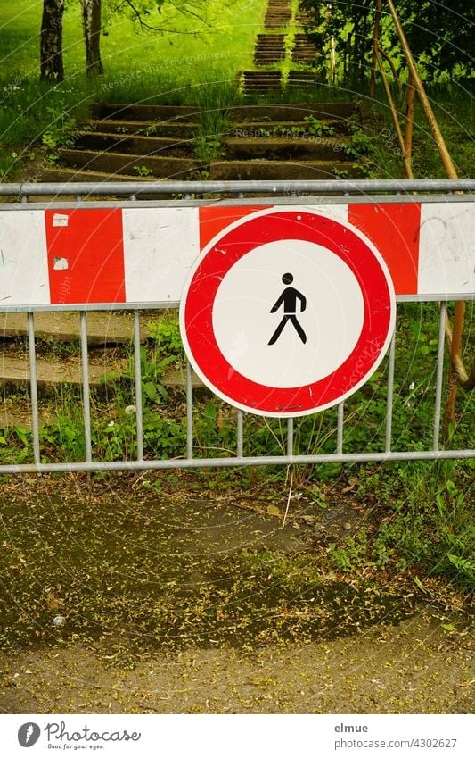 Verkehrszeichen " Verbot für Fußgänger" und rot-weiße Warnbake vor einer langen Treppe in einem Park / VZ 259 / Durchgangsverbot Piktogramm Kreis Eingangsverbot