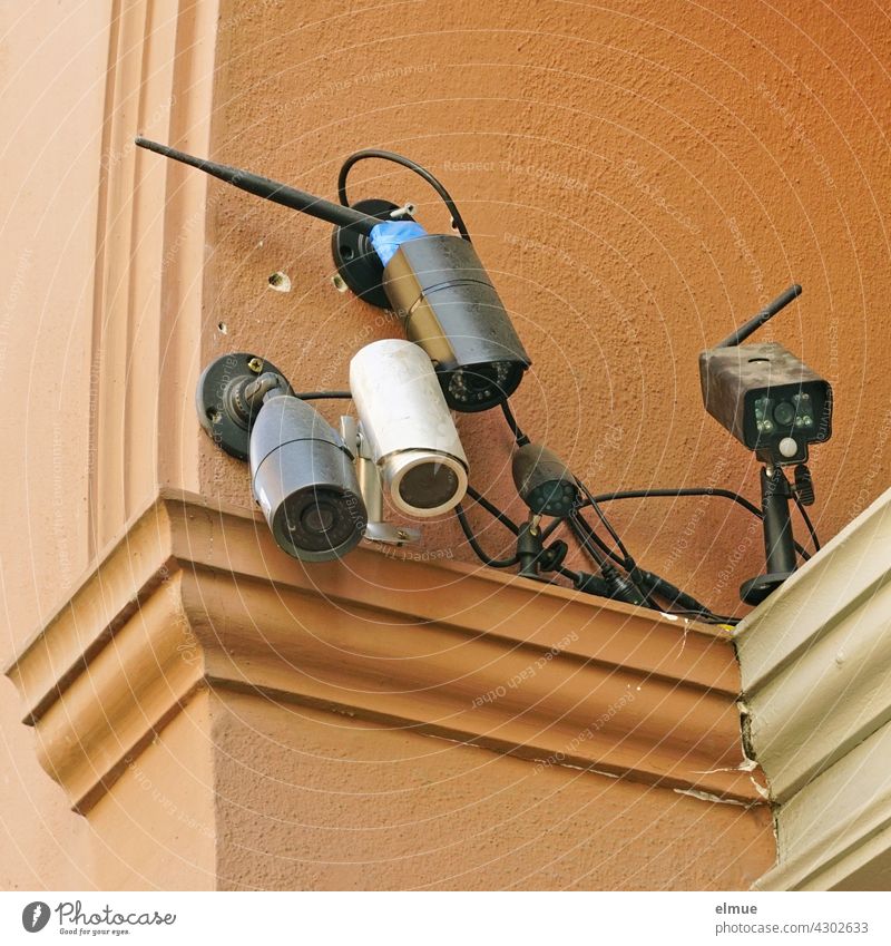 Fünf unterschiedliche Überwachungskameras sind auf einen Hauseingang gerichtet / Kontrolle / Misstrauen Technik Observation Sicherheit Sicherheitssystem