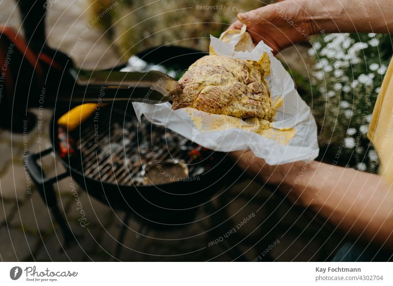 Hände, die ein rohes Steak mit einer Grillzange aufnehmen Hinterhof Barbecue Paprika Essen zubereiten Kochaktion Mais Maiskolben Tag lecker Lebensmittel