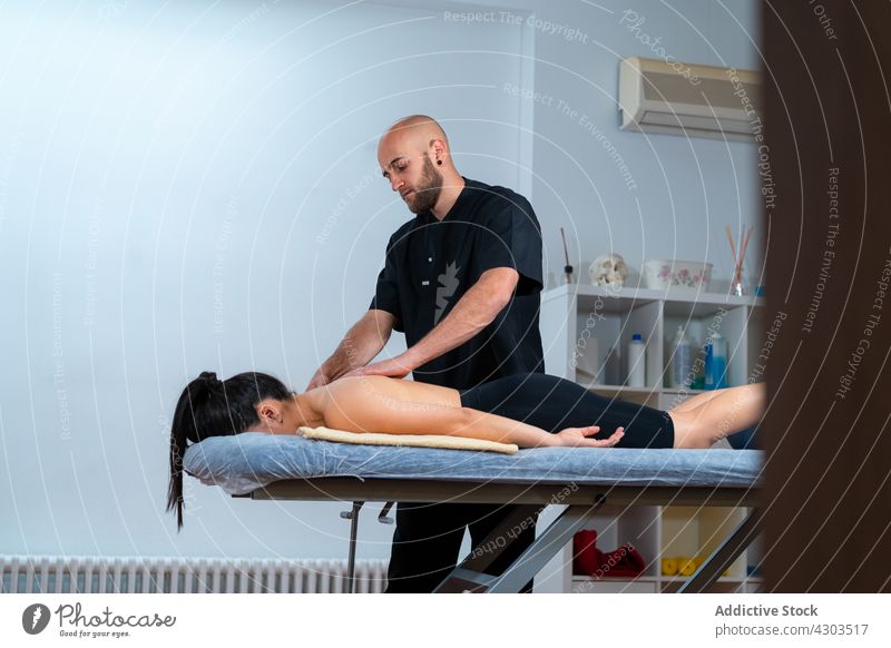 Physiotherapeutin massiert Rücken eines anonymen Patienten in der Klinik Massage geduldig Rehabilitation Wiederherstellung medizinisch Tisch Mann Frau