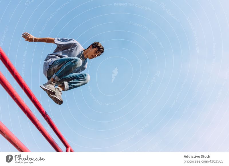 Junger Mann springt in der Stadt über ein Geländer Le Parkour springen Trick Reling Stunt Hindernis Moment Zaun urban männlich akrobatisch furchtlos extrem