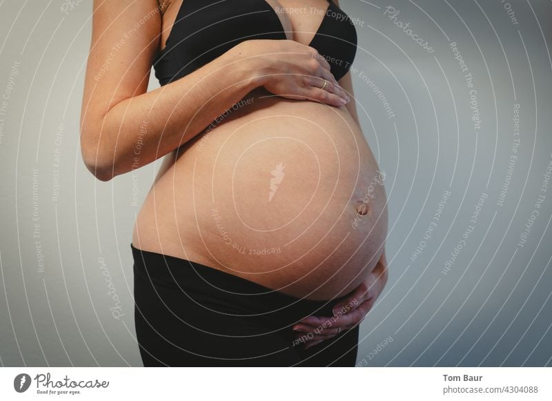 schwangere junge Frau in schwarzem BH hält ihren Babybauch 9. Monat Liebe Magen feminin Mutter Familie & Verwandtschaft Glück Leben Hand Erwachsene Farbfoto