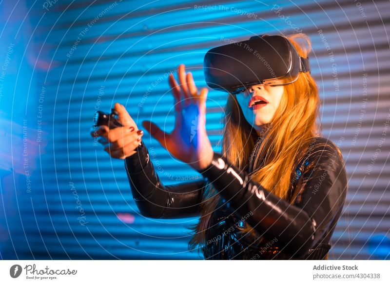 Erstaunte Frau erkundet virtuelle Realität spielen Videospiel VR erstaunt erkunden gestikulieren Regler interagieren unterhalten Technik & Technologie Gerät