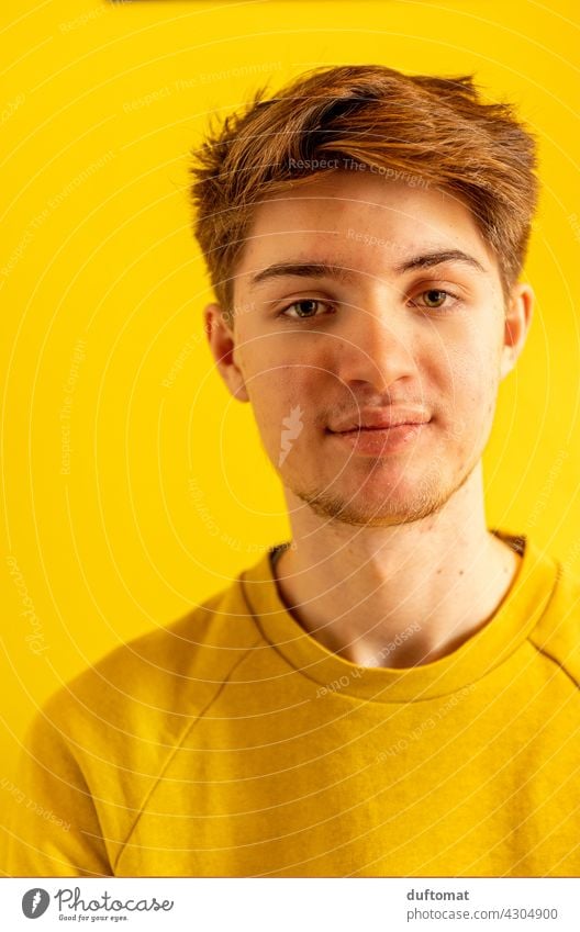 Portrait eines jungen Mannes vor gelbem Hintergrund Teenager Junge männlich Gesicht Bart Porträt gutaussehend attraktiv im Freien Model lässig Lifestyle