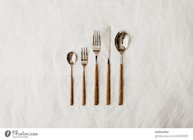 Metall-Besteck mit Holzgriff Zusammensetzung auf weißem Hintergrund Gabel Messer Löffel Silberwaren vereinzelt Küche Tisch Lebensmittel Abendessen Utensil