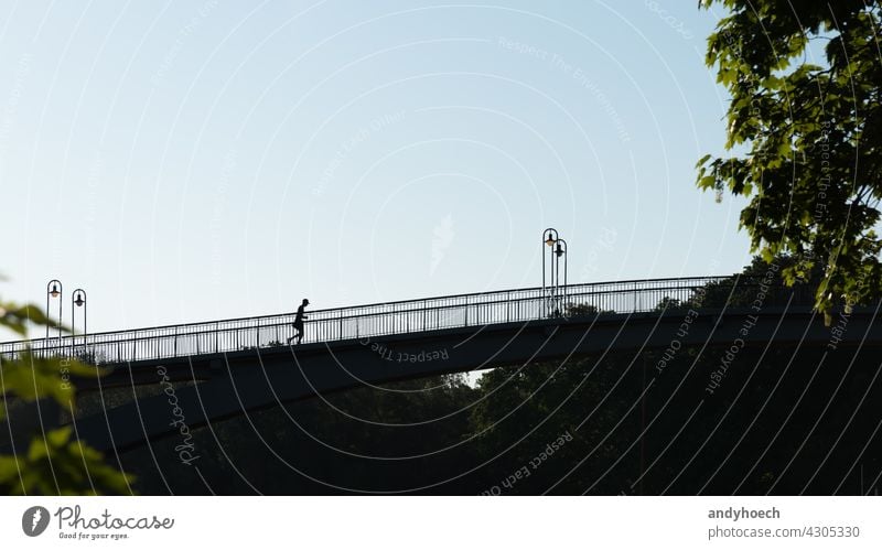 Silhouette eines Joggers auf einer Brücke Aktion aktiv Aktivität Erwachsener Athlet Sportler sportlich Leichtathletik Hintergrund hintergrundbeleuchtet