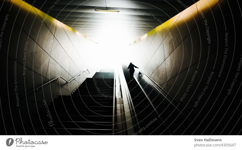 Mann steigt eine Treppe hinauf Treppenhaus Abstieg Schritt dunkel Treppenstufen taumeln Beine Altstadt Metall Gitterrost Metallgeländer diagonal hell und dunkel