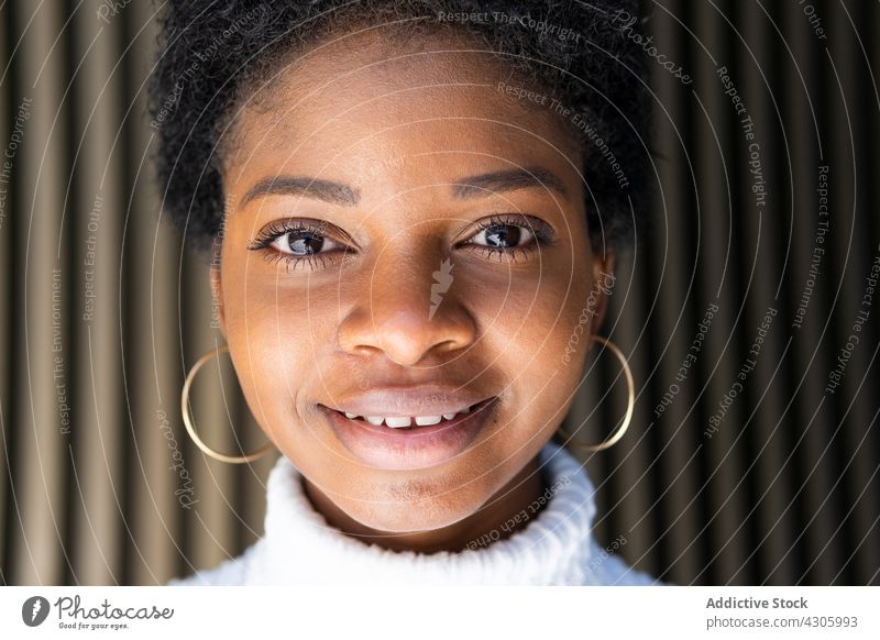 Junge Afroamerikanerin in der Nähe einer gestreiften Hauswand Frau Stil Wand Outfit modern urban Großstadt Straße Glück lässig Porträt Vorschein Lächeln Mode