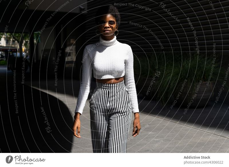 Trendige afroamerikanische Frau mit Sonnenbrille Stil Straße Großstadt modern sonnig tagsüber urban schlendern trendy Stadt Vorschein Outfit Mode jung ethnisch