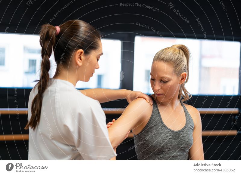 Physiotherapeutin passt Schultergelenk einer Frau an Osteopath Gelenk passen Schmerz geduldig Physiotherapie Klinik Sitzung Rehabilitation Verletzung Frauen