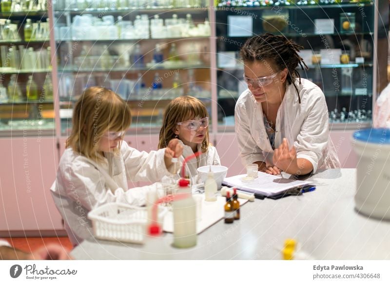 Kinder und ihr Lehrer im naturwissenschaftlichen Unterricht Experiment Experte Lernen Bildung Wissenschaft jung Menschen Frau Erwachsener Glück Sitzen Kaukasier