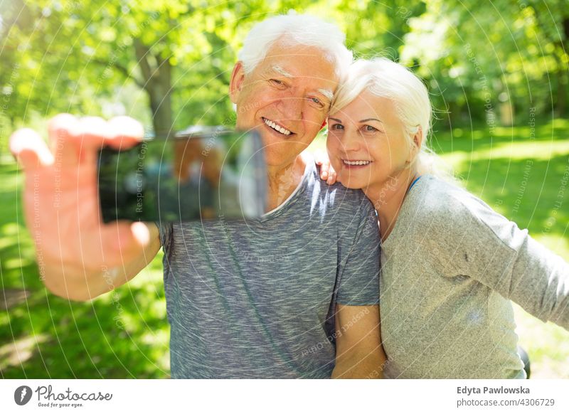 Senior Paar nimmt Selfie mobiles Foto Smartphone Fotografieren fotografierend Senioren Rentnerin Rentnerinnen lässig im Freien Tag Kaukasier Fröhlichkeit