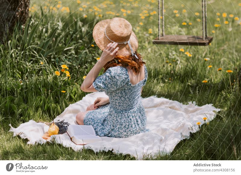 Frau auf Picknick-Decke in der Natur Sommer ruhen Strohhut Wiese sich[Akk] entspannen Landschaft Gras Wochenende Kleid Freizeit pendeln Literatur Erholung