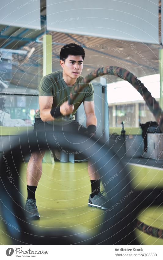 Asiatischer Mann trainiert mit Kampfseil asiatisch Athlet sportlich Schlacht Seile Körper Crossfit Übung passen Fitness operativ Fitnessstudio Gesundheit