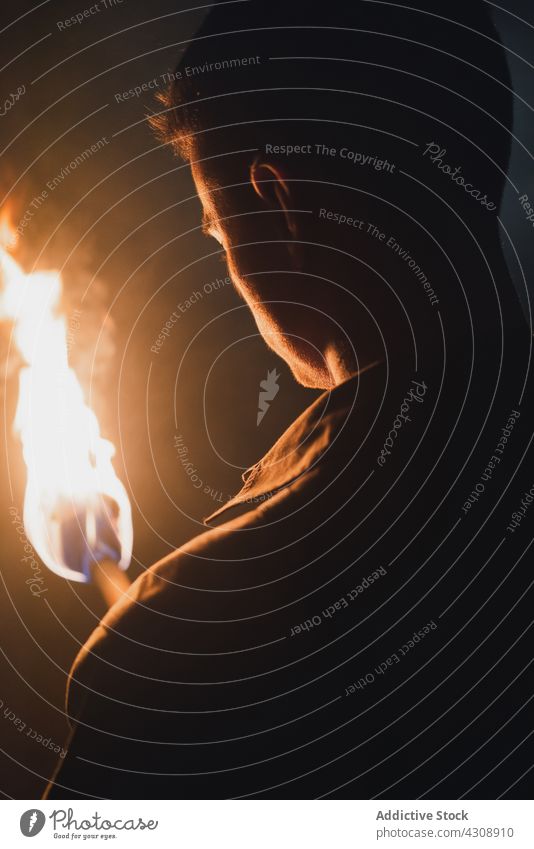 Mann mit brennendem Feuer in dunkler Höhle erkunden Speläologie dunkel Abenteuer felsig Natur Geologie männlich Fackel Felsen Stein reisen Tourismus