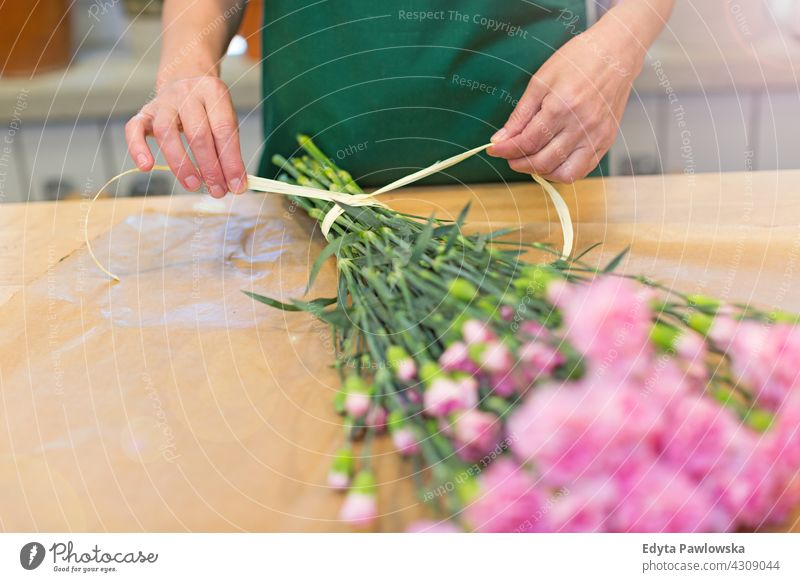 Florist bei der Arbeit Blumenhändler Haufen Blumenstrauß Beteiligung Menschen Senior reif Frau Mitarbeiter arbeiten Job Beruf Botaniker Überstrahlung Blühend