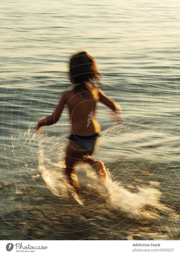 Glückliches Kind läuft im Meerwasser Strand Sommer MEER Wasser laufen platschen Spaß haben genießen Urlaub Kindheit Feiertag Natur sorgenfrei wenig Erholung