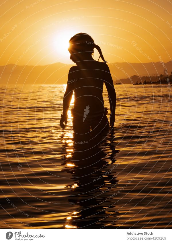 Glückliches Kind im Wasser bei Sonnenuntergang MEER Silhouette Mädchen Sommer Sonnenlicht Natur Urlaub Freiheit Freizeit Strand Erholung genießen Frau Abend