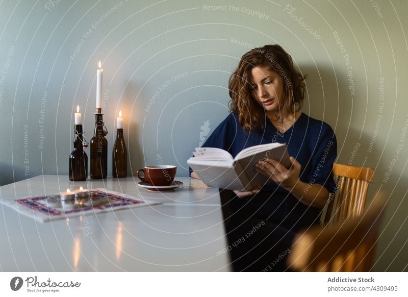 Frau liest Buch in der Nähe von Kerzen lesen ruhen heimwärts Tisch Dekor Hobby interessant Erwachsener Literatur Etage sich[Akk] entspannen Roman leuchten