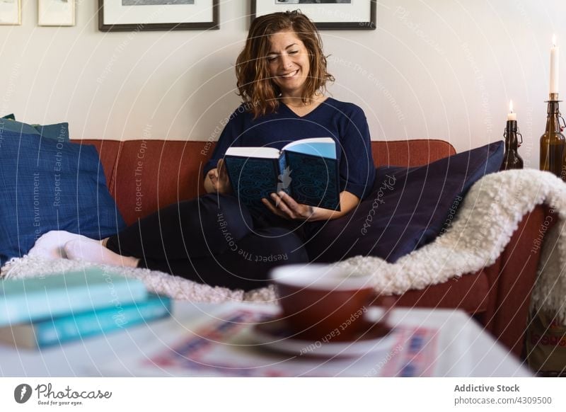 Verträumte Frau liest Buch auf Sofa lesen verträumt heimwärts ruhen Wochenende Hobby Wohnzimmer Erwachsener Liege sich[Akk] entspannen interessant Wissen froh