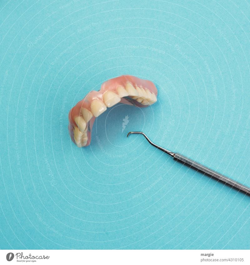 Künstliche Zähne, Gebiss mit Zahnreinigungsgerät Mund Nahaufnahme Detailaufnahme Model Kiefer Labor zahngesundheit senioren altern skuril Künstliche zähne
