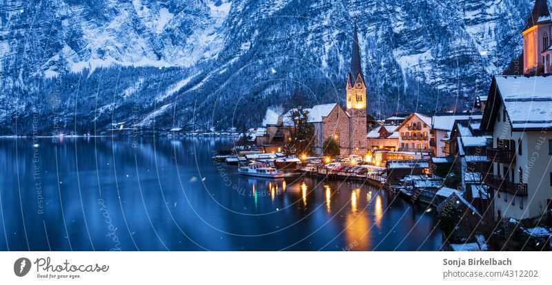Hallstatt am Hallstättersee mit beleuchteter Kirche an einem Winterabend, Österreich hallstatt hallstättersee österreich sehenswürdigkeit winter alpen alpendorf