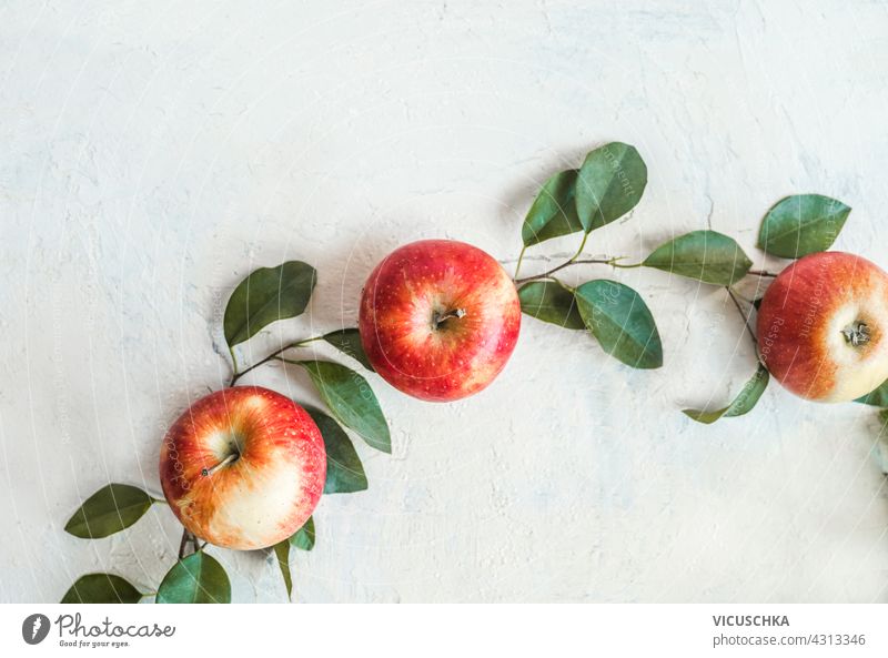 Rote Äpfel auf weißem Tisch mit grünen Blättern, oben vew rot grüne Blätter Top Apfel roh Farbe Pflanze saftig reif Blatt Frucht Gesundheit Lebensmittel