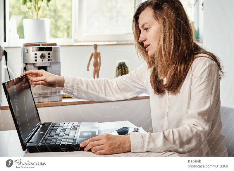 Frau arbeitet im Home-Office mit Laptop aus der Ferne abgelegen freiberuflich online Arbeit prokrastinieren Bildung Smartphone e Lernen Business Arbeitsbereich