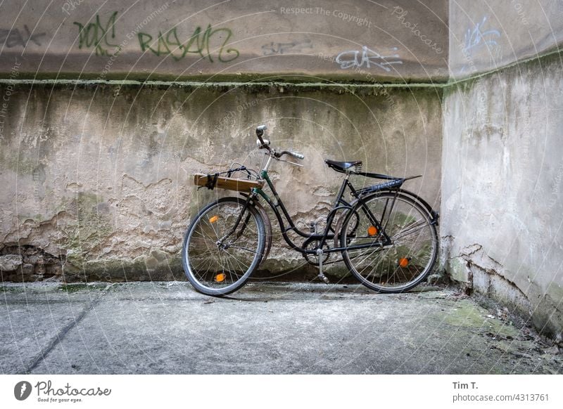ein altes Fahrrad im Hinterhof and die Mauer gelehnt Prenzlauer Berg Berlin Rad Stadt Menschenleer Außenaufnahme Tag Hauptstadt Stadtzentrum Altstadt Altbau