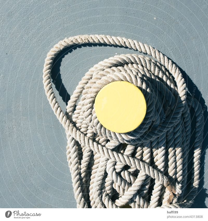 Seil um einen Poller an einer Anlegestelle am Hafen minimalistisch maritim festmachen Schlinge Seile Bündel Befestigung Schifffahrt ankern Jachthafen