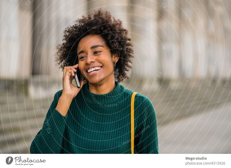 Geschäftsfrau beim Telefonieren im Freien. Afro-Look Business Frau Mobile reden modern Stil brünett Apparatur positiv Konzept Anschluss Anwendung SMS Texten