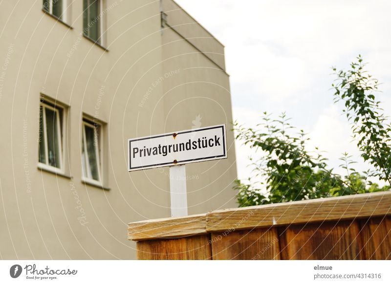 Privatgrundstück steht auf dem Schild an der Einfahrt zu einem mehrstöckigen Haus / Grundstückseigentum Wohnhaus wohnen Privateigentum Hauseigentum Hinweis Zaun