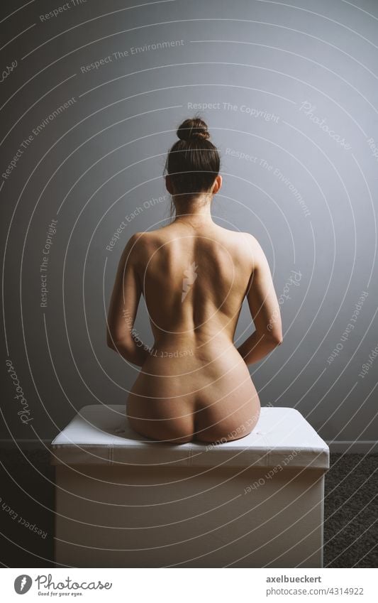 Weiblicher Rückenakt sitzend Frau nackt Weiblicher Akt feminin Körper Erotik Frauenkörper Erwachsene Junge Frau von hinten Dutt brünett anonym unkenntlich