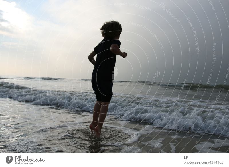 Kontrast Silhouette eines Kindes springen im Meer Outdoor-Erholung Strukturen & Formen Spielen Meeresstrand stimmig Wohlgefühl Hintergrund neutral Tag Beginn