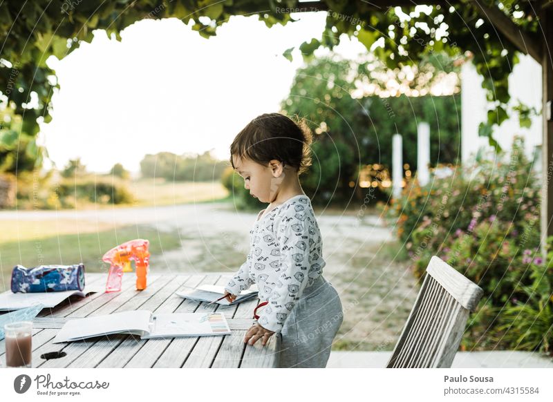 Kind liest ein Buch in der Tabelle 1-3 Jahre Kaukasier Tag Glück Kindheit Kleinkind Freude Farbfoto Außenaufnahme Leben Freizeit & Hobby Fröhlichkeit Spielen