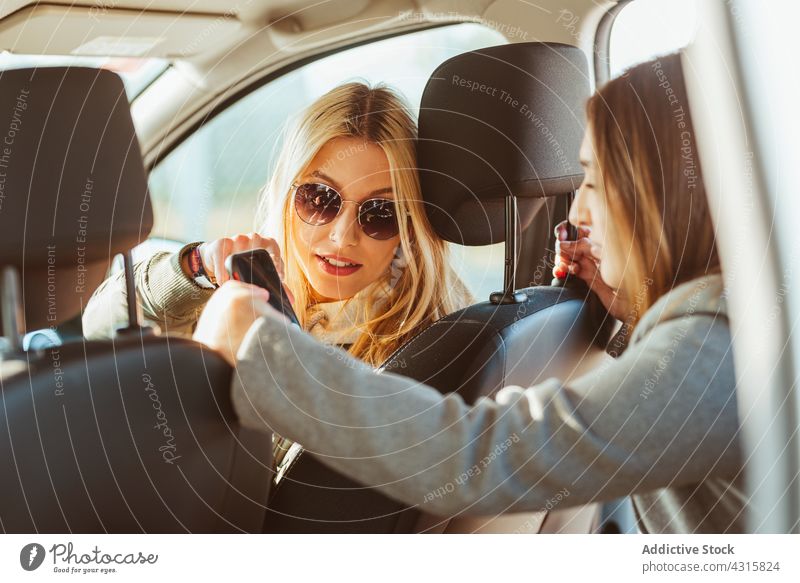 Frauen mit Telefon im Auto Mitfahrgelegenheit PKW teilen Smartphone zeigen Freundin Fahrzeug Verkehr bester Freund Freundschaft Gerät Apparatur Reise Anschluss