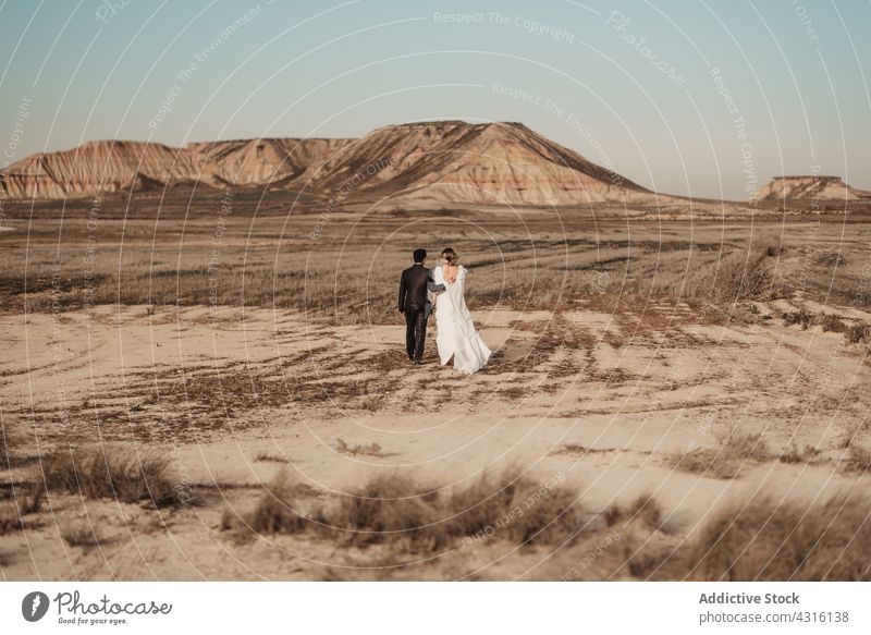 Anonymes Paar beim Spaziergang in der Wüste am Hochzeitstag Jungvermählter wüst Ebene Berge u. Gebirge Zusammensein Mann Frau Navarra Spanien bardenas reales